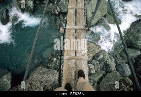 Mann auf einer Hängebrücke über die Rees Dart River, Mount Aspiring Nationalpark, Südinsel, Neuseeland, Ozeanien Stockfoto