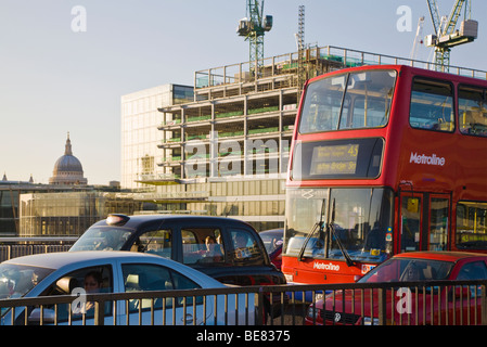 Verkehr auf der London Bridge und Aufbau vor Ort. London. VEREINIGTES KÖNIGREICH. Kuppel der St. Pauls Kathedrale in der Ferne. Stockfoto