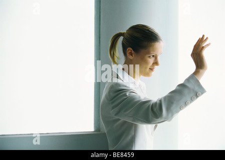 Frau winken, seitliche Ansicht Stockfoto