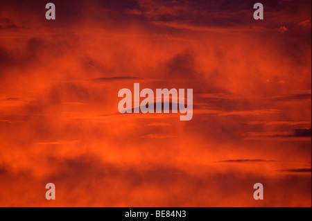 Linsenförmige Wolken im Bild gegen ein tief rot und Orange feurigen Sonnenuntergang Blick fast wie fremde Besucher in den Himmel Stockfoto