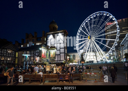 Das alte Wellington Inn in der Nacht mit dem Manchester-Rad hinter Exchange Square, Manchester, England Stockfoto