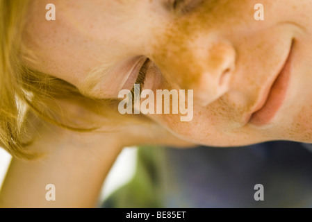 Junge hält Kopf und Lächeln auf den Lippen, Augen geschlossen Stockfoto