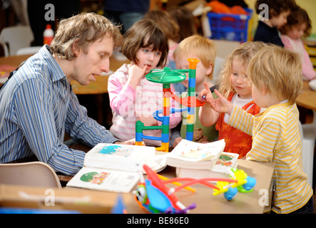 KLEINE KINDER SPIELEN IN EINER GRUPPE AN EINEM SONNTAG SCHOOL UK Stockfoto