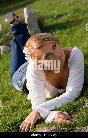 Schöne junge Frau, die Verlegung auf dem Rasen. Stockfoto