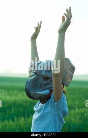Im Freien tragen Elefant Maske Mädchen, hob die Arme Stockfoto