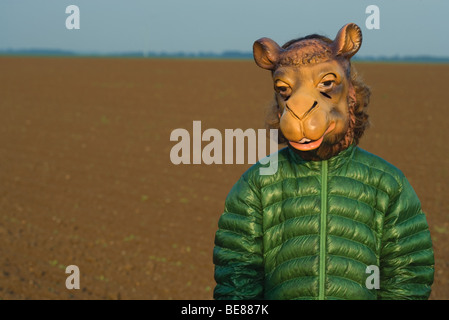 Person im Feld stehen, Kamel Maske trägt Stockfoto