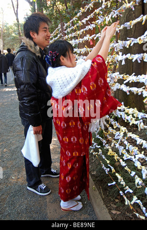 JAPAN Tokio Jingumae Honshu - Meijijingu Schrein paar binden Omikuji Silvester Vorhersage an einen Zaun Stockfoto