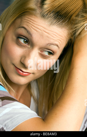 Blonde, junge Frau, die ihre langen Haare kämmen. Stockfoto