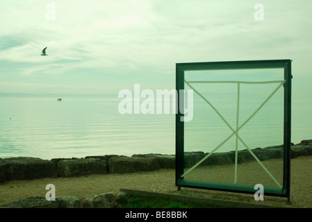 Fenster mit Glas mit Klebeband am Meer, Möwe, fliegen im Hintergrund Stockfoto