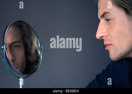 Mann sucht bei self in Kosmetikspiegel Stockfoto