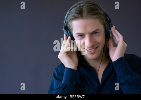 Mann lächelnd, anhören von Musik über Kopfhörer Stockfoto