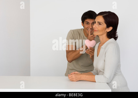 Mann mit Finger, Lippen, Mutter mit rosa Herzen überraschen wird vorbereitet Stockfoto