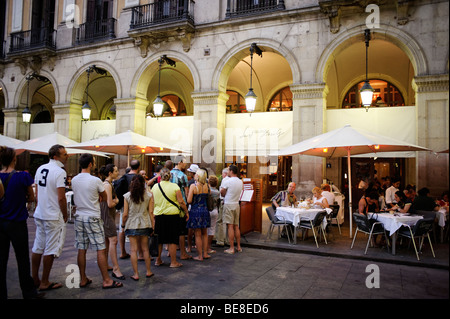 Touristen, die Schlange im beliebten Restaurant Les Quinze Nits am Plaza Reial. Barcelona. Spanien Stockfoto