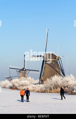 Schaatsers Schaatsen Langs de Molens van Kinderdijk; Eisläufer Skate entlang der Windmühlen von Kinderdijk Stockfoto