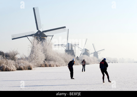 Schaatsers Schaatsen Langs de Molens van Kinderdijk; Eisläufer Skate entlang der Windmühlen von Kinderdijk Stockfoto