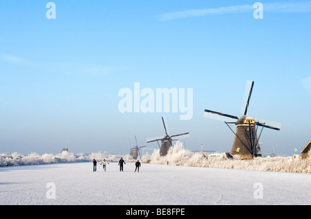 Schaatsers Schaatsen Langs de Molens van Kinderdijk; Eisläufer Skate entlang der Windmühlen von Kinderdijk Stockfoto