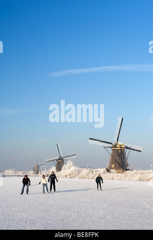 Schaatsers Schaatsen Langs de Molens van Kinderdijk; Eisläufer Skate entlang der Windmühlen von Kinderdijk Stockfoto