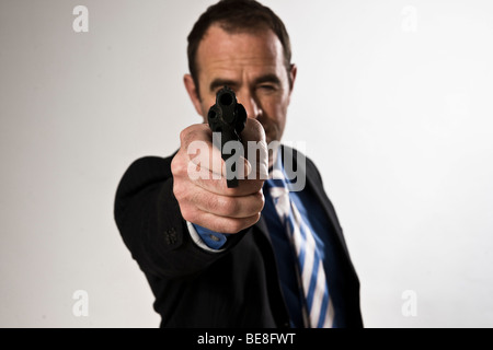 Mann trägt einen Anzug mit einer Pistole Stockfoto