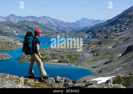 Junge Frau, die genießen des Panoramas am Gipfel des historischen Chilkoot Trail, Chilkoot Pass, Kratersee hinter alpine Tundra, Yukon Stockfoto