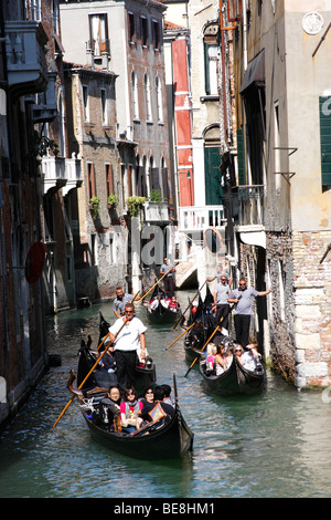 Eine Bootsfahrt durch die wunderschönen Grachten der Stadt übernehmen Gondolieri Touristen nach Venedig. Italien Stockfoto