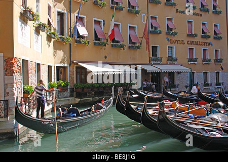 Eine Bootsfahrt durch die wunderschönen Grachten der Stadt übernehmen Gondolieri Touristen nach Venedig. Italien Stockfoto