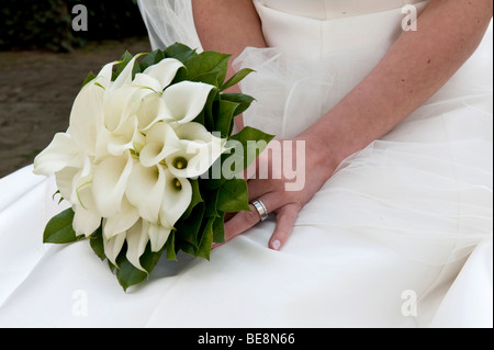 Brautstrauß weiße Callas in den Schoß der Braut Stockfoto