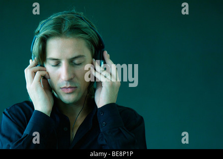 Mann mit Augen geschlossen Musik über Kopfhörer hören Stockfoto