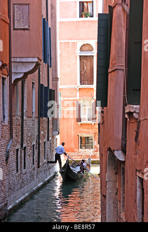 Eine Bootsfahrt durch die wunderschönen Grachten der Stadt übernehmen Gondolieri Touristen nach Venedig. Italien Stockfoto