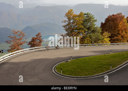 Fahrrad Racers in einer Kurve auf der Mendel pass oberhalb von Kaltern, in der Rückseite der Lago di Caldaro See, Südtirol, Italien, Europa Stockfoto