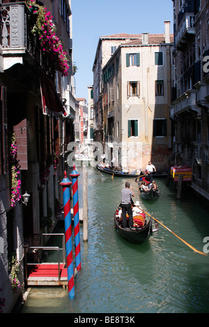 Eine Bootsfahrt durch die wunderschönen Grachten der Stadt übernehmen Gondolieri Touristen nach Venedig. Italien Stockfoto