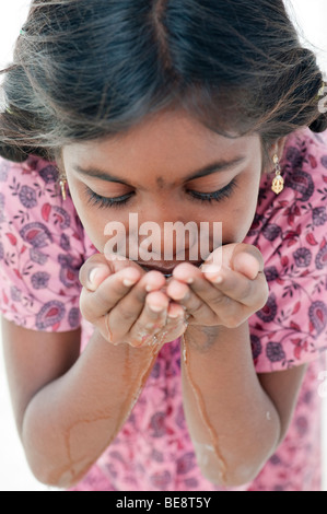 Indisches Mädchen mit hohlen Händen Trinkwasser. Indien Stockfoto