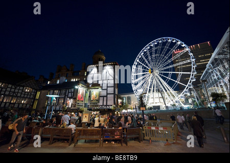 Das alte Wellington Inn in der Nacht mit dem Manchester-Rad hinter Exchange Square, Manchester, England Stockfoto