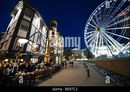 Kneipe in der Nacht mit dem Manchester-Rad hinter Exchange Square, Manchester, England Stockfoto