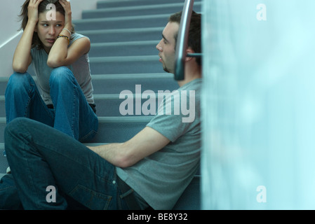 Junges Paar sitzt auf der Treppe, angespannten Gespräch Stockfoto