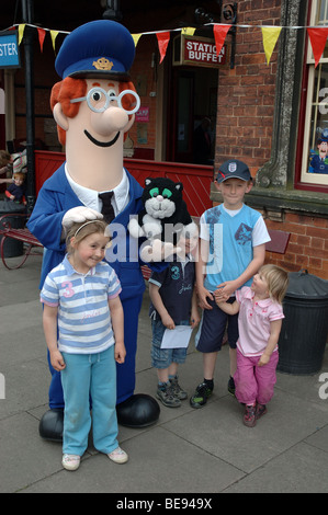 Postbote Pat mit Kindern an der Shackerstone Station auf dem Schlachtfeld Museumsbahn, Leicestershire, England, UK Stockfoto