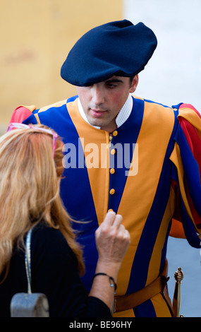 Italien Lazio Rom Vatikanstadt A Schweizergarde Soldat in volle zeremoniellen uniform Kleid im Gespräch mit einem weiblichen Touristen. Stockfoto