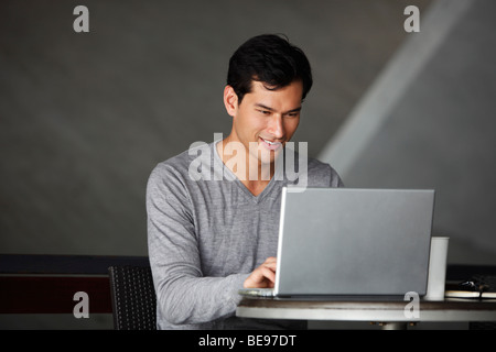 Asiatischer Mann auf laptop Stockfoto