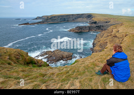 eine junge Frau, die Aussicht in der Nähe von Kilkee im County Clare an der Westküste von Irland Stockfoto