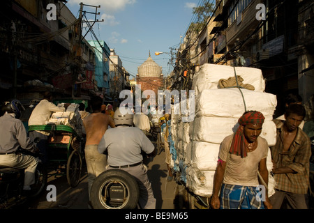 Ein Mann kämpft sich durch die verstopften Straßen von Old Delhi ziehen einen schwer beladenen Karren, Delhi, Indien Stockfoto