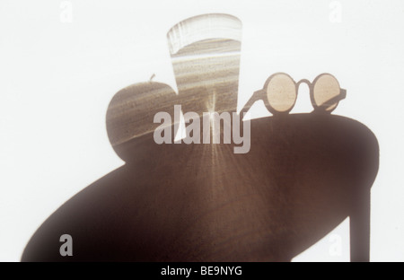 Schatten Sie auf weiße strukturierte Wand der Rundtisch mit Apfel und Sonnenbrille und Glas Wasser gießen gebrochene Reflexionen Stockfoto