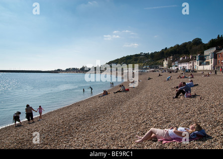 Urlauber am Kiesstrand bei Lyme Regis, Dorset Stockfoto