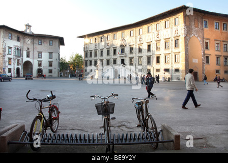 Fahrräder in Piazza dei Cavillieri aufgereiht, entworfen von Vasari in der Größenordnung von Cosimo I, mit Scuola Normale Superiore (r), Pisa Stockfoto