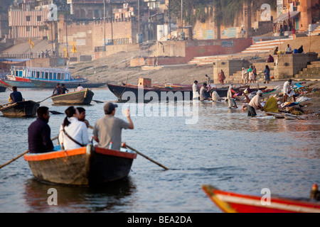 Boot von Touristen gerade Wäsche im Fluss Ganges in Varanasi, Indien Stockfoto