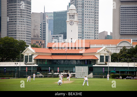 Schülerinnen und Schüler spielen Cricket auf dem Padang in Singapore Cricket Club Stockfoto