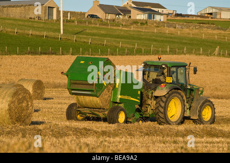 dh John Deere Traktor BALLENPRESSE ERNTE UK Ballenfeld Ernte Heuballen Maschine Landwirtschaft in orkney schottland Maschinen Traktoren Rollen Stockfoto