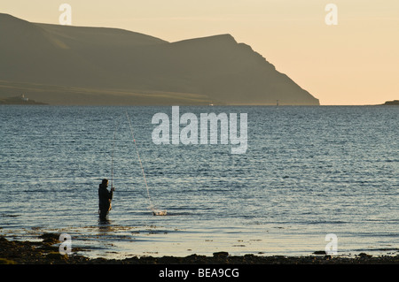 Dh angler angeln SCAPA FLOW ORKNEY Schottland Waten fisherman off shore Abend Hoy Hills casting Stockfoto