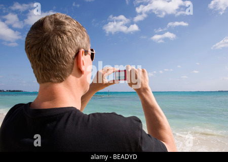 Rückansicht eines Mannes mit einer digitalen Kamera, Cable Beach, Nassau, Bahamas, Caribbean Stockfoto