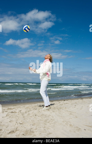 Eine ältere Frau werfen und fangen einen Fußball Stockfoto