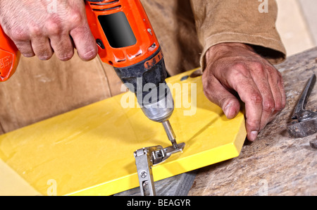 Tischler mit roten Bohrer beim Arbeiten, industriellen Hintergrund Stockfoto