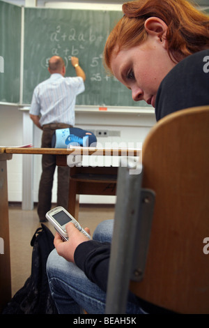 Mädchen-SMS während einer Unterrichtsstunde Stockfoto